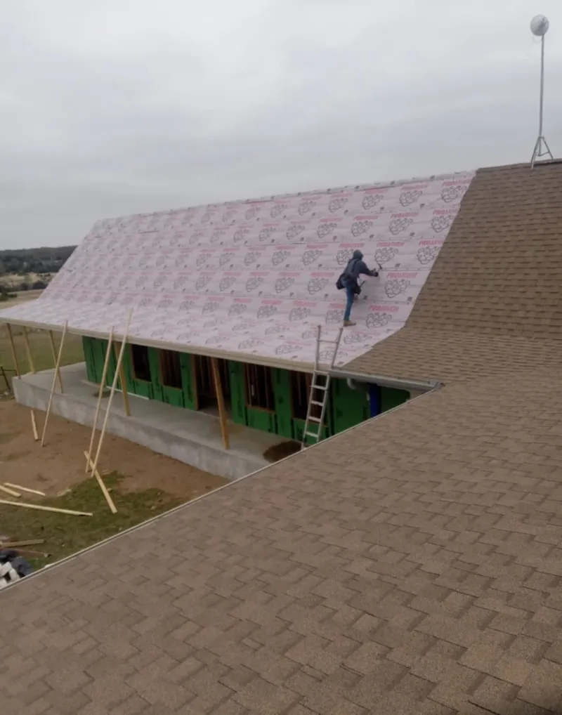 Worker preparing underlayment for a metal roof installation in Tuckahoe